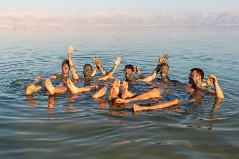 Turisti che godono di una vacanza al Mar Morto in Giordania tra spiagge e fanghi naturali