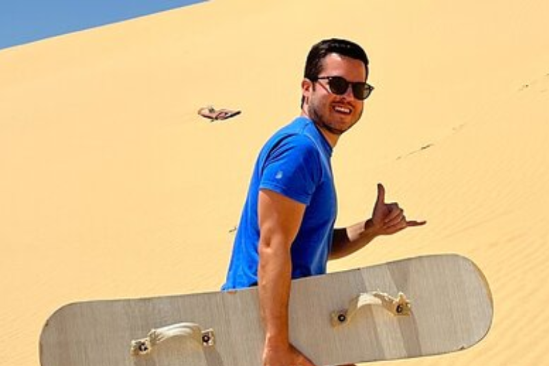 sandboarding sulle dune dorate vicino al Magic Lake nel Fayoum, Egitto.