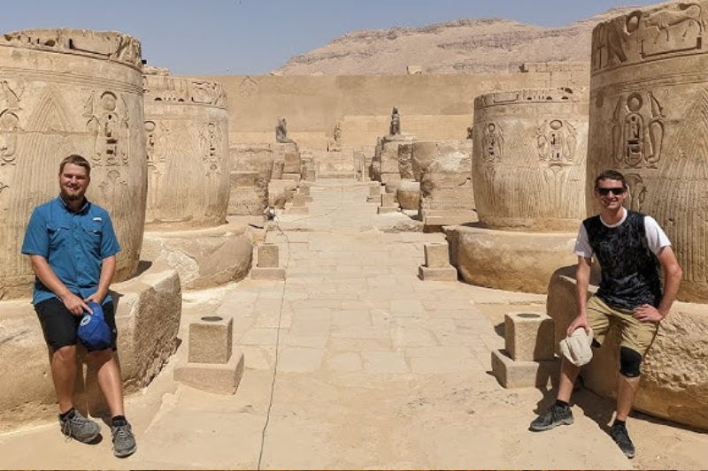 Turisti che esplorano le sale interne del tempio di Medinet Habu.